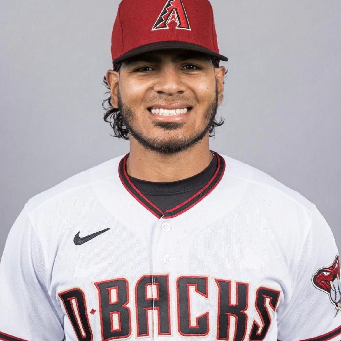 Baseball player wearing an Arizona Diamondbacks uniform with a red cap.
